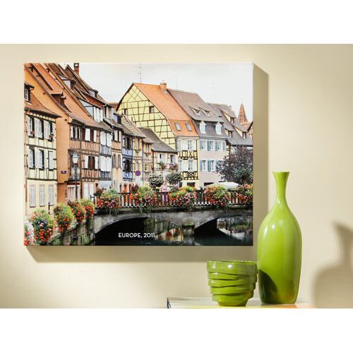 Colorful canvas print of European architecture with flowers, titled 'EUROPE, 2011', displayed on a wall.